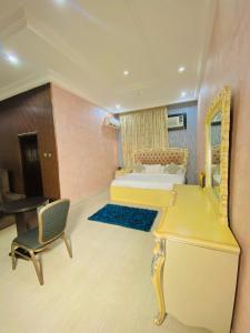a bedroom with a bed and a desk with a mirror at Garden Atlantis Hotel in Enugu +5 photos