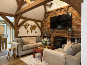 a living room with a brick wall with a flat screen tv at The barn Alexandra mews in Heathfield