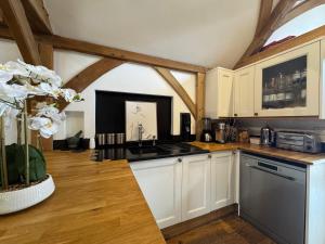 a kitchen with white cabinets and a counter top at The barn Alexandra mews in Heathfield