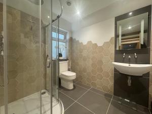 a bathroom with a toilet and a sink and a shower at The barn Alexandra mews in Heathfield +19 photos