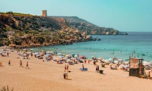 a group of people on a beach with umbrellas at 11 St Joseph in Birgu