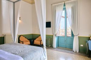 a bedroom with a bed and a window and a door at Palazzo Mercanzia in Lecce
