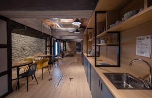 a kitchen with wooden counters and chairs and a table at Font Andorra Hostel by Nexta in La Massana