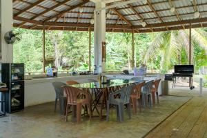 a dining room with a table and chairs and a piano at Utopia Hostel in Ngermid