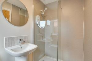 a bathroom with a sink and a shower with a mirror at 5 Bed in Seahouses oc-nb621 in Seahouses +17 photos