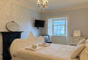 a bedroom with a bed with towels on it at Luxury Georgian Townhouse Tenby Sleeps 8 Parking Permit in Tenby