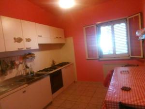 a kitchen with white cabinets and a table and a window at Camera singola in affitto con bagno privato interno in Montenero di Bisaccia +16 photos