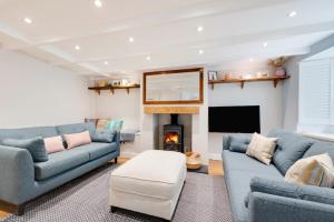 a living room with two blue couches and a fireplace at 2 Bed in Newlyn oc-oldbak in Newlyn
