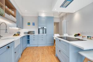 a kitchen with blue cabinets and a wooden floor at 2 Bed in Newlyn oc-oldbak in Newlyn