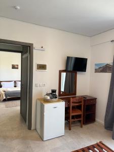 a room with a refrigerator and a table and a television at Escape at Chalandri Athens in Athens