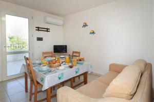 a living room with a table and a couch at Attico Fronte Mare in Torre Mozza +3 photos