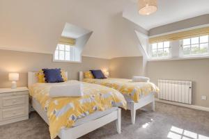 a bedroom with two beds and two windows at 2 Bed in Beadnell oc-gd1889 in Beadnell