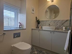 a bathroom with a toilet and a sink and a mirror at 2 Bed in Beadnell oc-gd1889 in Beadnell +11 photos