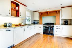 a kitchen with white cabinets and a wooden floor at 2 Bed in Beadnell oc-gd1869 in Beadnell +9 photos
