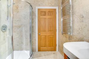 a bathroom with a shower and a wooden door at 2 Bed in Beadnell oc-gd1869 in Beadnell
