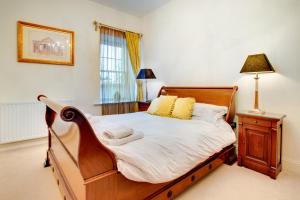 a bedroom with a wooden bed with white sheets and a lamp at 2 Bed in Beadnell oc-gd1869 in Beadnell