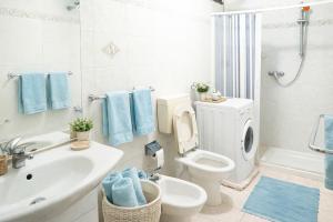 a white bathroom with a toilet and a sink at Casa Saracino 3 - Semplicità Mediterranea in Marina di Pescoluse
