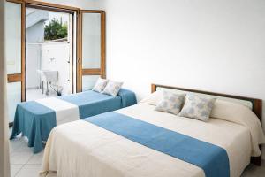 a bedroom with two beds and a window at Casa Saracino 3 - Semplicità Mediterranea in Marina di Pescoluse