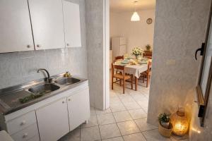 a kitchen with a sink and a dining table at Casa Saracino 3 - Semplicità Mediterranea in Marina di Pescoluse