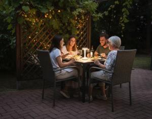 a group of people sitting around a table eating at Große Ferienwohnung im Spreewald Lübben 2,5km in Hartmannsdorf