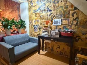a room with a blue couch and a table with books at Dou Houz Georgetown in George Town