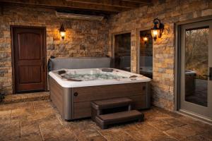 a jacuzzi tub in a room with a brick wall at The Bunkhouse at Rock Canyon in Branson