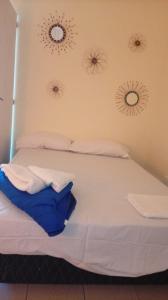 a white bed with two mirrors on the wall at Lo de Julia in Formosa