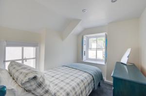 a bedroom with a bed and a desk and windows at 2 Bed in West Looe oc-l30054 in Looe