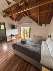 a bedroom with a large bed and a table at Hostería Cumbres Blancas in Esquel
