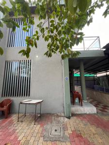 a table and a bench in front of a building at Green Heaven Stay in Surat