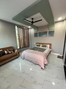 a bedroom with a bed and a couch in it at Green Heaven Stay in Surat