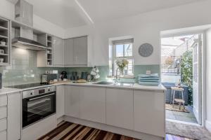 a kitchen with white cabinets and a large window at 1 Bed in Cerrigydrudion oc-bow194 in Cerrig-y-Druidion