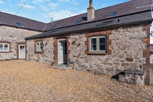 an old stone house with a gravel driveway at 1 Bed in Cilcain oc-s29009 in Cilcain