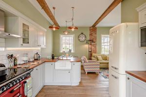 a kitchen with white cabinets and a living room at 2 Bed in Blythburgh oc-t27735 in Blyford