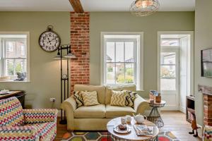 a living room with a couch and a clock on the wall at 2 Bed in Blythburgh oc-t27735 in Blyford