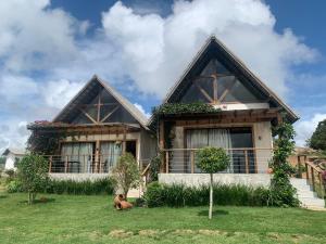 a house with a dog sitting in front of it at Chalé I - Village da Serra in Serra de São Bento