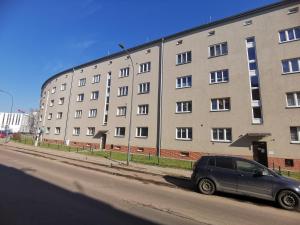 a car parked in front of a large building at Apartment - Aloha - Parter - Self check 24h in Bytom
