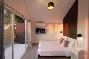 a bedroom with a bed and a tv on the wall at Wawee Sunset, Doi Chang Chiang Rai in Ban Huai Khai