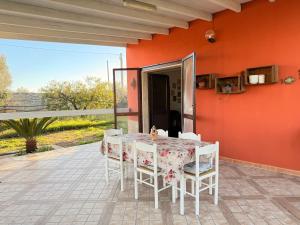 a dining room with a table and chairs on a patio at Villa Flora Gallipoli in Il Monte