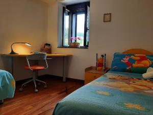 a bedroom with a bed and a desk and a deskablish at Tenuta Kiwi dell’Etna in Milo