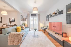 a living room with a blue couch and a tv at GuestReady - Charming Oeiras apartment in Oeiras
