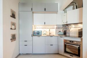 a kitchen with white cabinets and a sink at GuestReady - Charming Oeiras apartment in Oeiras