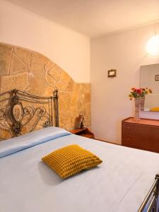 a bedroom with a large bed with a yellow pillow at Villa Flora Gallipoli in Il Monte