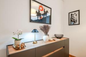 a dresser in a living room with a picture on the wall at GuestReady - Charming Oeiras apartment in Oeiras