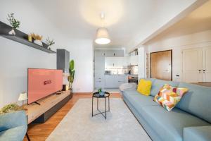 a living room with a blue couch and a tv at GuestReady - Charming Oeiras apartment in Oeiras +28 photos
