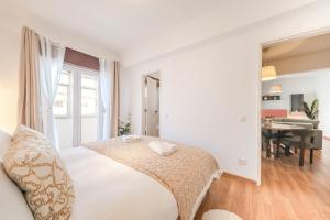 a white bedroom with a bed and a desk at GuestReady - Charming Oeiras apartment in Oeiras