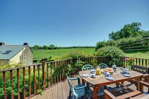 a wooden table and chairs on a wooden deck at 3 Bed in St Columb oc-trembl in Saint Mawgan