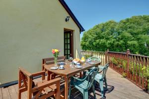 a wooden table and chairs on a wooden deck at 3 Bed in St Columb oc-trembl in Saint Mawgan