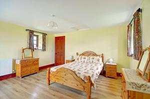 a bedroom with a bed and two dressers and a mirror at 3 Bed in St Columb oc-trembl in Saint Mawgan