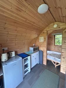 a kitchen in a log cabin with a window at Ronam Glamping 2 Berth Pod in Anderby